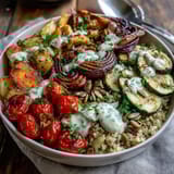 Colorful medley of bell pepper, zucchini, and cherry tomatoes in a Roasted Vegetable Quinoa Bowl, finished with parsley.