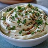 Smooth and glossy homemade garlic aioli, made with fresh lemon and Dijon, ideal for seafood and vegetable platters.  