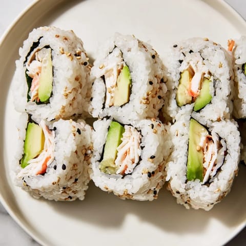 Beautifully arranged California Rolls, glistening with sesame seeds and waiting to be dipped in soy sauce.