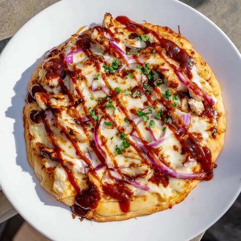 Golden, bubbly Chicken BBQ Pizza, showcasing smoky grilled chicken, onions, and melted cheese just out of oven.