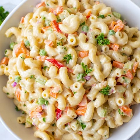 Creamy macaroni salad, chilled and ready for a picnic, featuring colorful vegetables.
