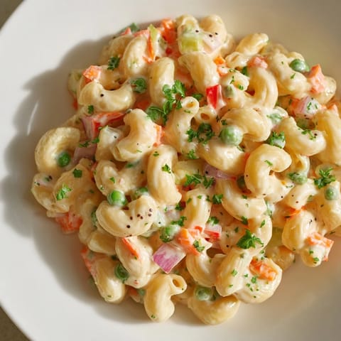 Delicious, homemade macaroni salad, perfectly dressed and ready to enjoy at a summer gathering.