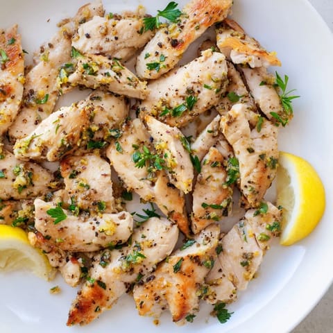 Close-up of pan-seared Lemon Pepper Chicken, perfectly seasoned with cracked black pepper and lemon zest.