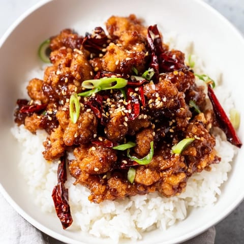 A close-up of tender General Tso's Chicken coated in a flavorful glaze, ideal dinner.
