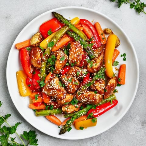 Tender chicken and vibrant vegetables roasted on a single sheet pan, drizzled with a glossy honey garlic sauce for a busy weeknight dinner.
