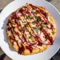 Golden, bubbly Chicken BBQ Pizza, showcasing smoky grilled chicken, onions, and melted cheese just out of oven.