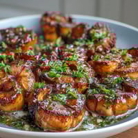Lemon butter scallops sizzling in a golden skillet with a glossy citrus sauce and fresh parsley.  